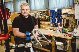 Mechanik Miro v dílně pro stavbu tříkolek pro dospělé